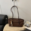 Dark brown suede tote bag with shoulder strap and beaded charm in a cozy setup - With Pendant / Brown