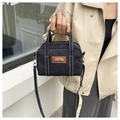 Dettaglio borsa a tracolla in denim con cuciture bianche e tracolla in pelle regolabile - Nero