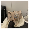 Beige Leder-Umhängetasche im Punk-Stil mit Metallnieten und großer Schnalle auf Ledersessel - Khaki