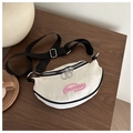 Bolso bandolera FANYISSA crema con borde negro y bordado rosa sobre superficie de madera - Blanco