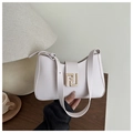 Primer plano detallado del bolso hobo vintage color crema con hebilla de metal dorado - Blanco