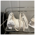 Minimalist creamy white crescent tote bag with plush charm on a modern display stand - With Cloud Charm / White