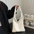White faux leather tote bag with silver studs and wide shoulder strap detail - White