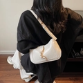 White faux leather baguette bag with gold hook, worn as a stylish shoulder underarm bag - Off White