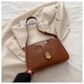 Detail of vintage brown shoulder bag with unique golden metallic leaf-shaped buckle - Brown