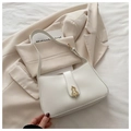Detail of white vintage underarm bag featuring a gold abstract buckle on soft leather - White