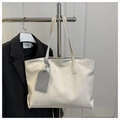 Dettaglio borsa tote in pelle bianca con trama a pieghe e ciondolo alla moda - Bianco