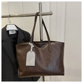 Dettaglio della morbida ecopelle marrone e della tracolla sulla grande borsa tote da donna - Marrone