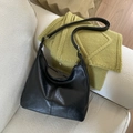 Borsa hobo minimalista in ecopelle nera opaca su sfondo in tessuto accogliente - Nero