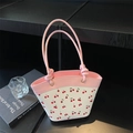 Bolso cubo rosa y blanco con estampado de cerezas y asas anudadas en un soporte - Rosa