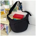Detail of minimalist black nylon crossbody bag with adjustable strap and buckle closure - Black