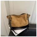 Detail of quilted stitching and gold-tone chain on the brown and black tote bag - Brown
