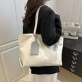 Minimalist creamy white large tote bag with textured leather and grey charm pendant - White