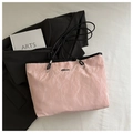Detailed macro view of pink crinkled texture tote bag with silver metal logo plaque - Pink (No Charm)