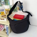 Minimalist black nylon crescent tote bag with adjustable shoulder strap and matte texture - Black