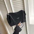 Minimalist black tote bag with silver chain strap shown in front of white shutters - Black