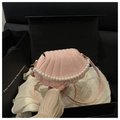 Detalle de bolso bandolera rosa de concha con grabado de serpiente y adorno de perlas - Rosa