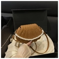 Detalle de un bolso marrón con forma de concha, textura de serpiente y decoración de perlas - Marrón