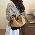 Borsa tote trapuntata in camoscio marrone con base in pelle nera indossata da modella - Marrone