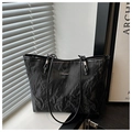 Close-up of black pleated tote bag detail showing metallic logo and wrinkled texture - Black (Without Charm)