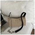 Close-up of beige nylon shoulder bag with silver chain detail and black strap on bed - Khaki