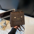 Mochila vintage de cuero sintético marrón con cierre dorado en un ambiente de oficina - café