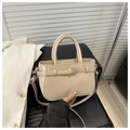 Detail view of beige square crossbody bag with silver buckle on black leather seat - Khaki
