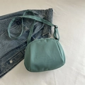 Minimalist mint green crossbody shell bag with adjustable strap on white textile - Green