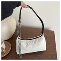 Close-up of cream pleated shoulder bag with silver chain detail on wood table - White