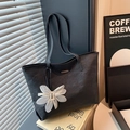 Large black tote bag with floral pendant and pleated texture for minimalist summer commuting - With Charm / Black