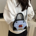 Blue and white plaid handbag with red apple pattern shown on a female model - Black