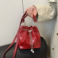Glossy red patent leather bucket bag with elegant pearl chain and adjustable strap - Red