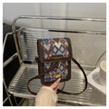 Dettaglio della trama geometrica e del bordo in pelle marrone sulla borsa a tracolla - Blu