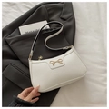 Detail of white lychee leather texture and gold bow buckle on elegant baguette bag - White Lychee Pattern Bow Style / White