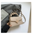 Close-up of beige quilted bag with golden geometric lock and ruffled cloud handle - Dark Khaki