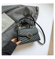 Detail of black quilted leather handbag with gold buckle and ruched handle texture - Black