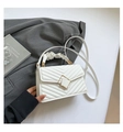 Detail of white quilted crossbody bag with golden buckle and ruffled top handle - White