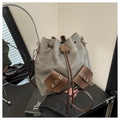 Detalle del bolso tipo cubo de lona vintage con bolsillos de cuero y cordón ajustable - Gris Cemento