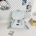 Detail of light gray water-resistant backpack with drawstring closure and logo on desk - Large Gray No Charm