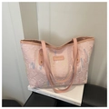 Detail der rosa Tragetasche mit bunten Wellenstickereien und Metall-Namensschild - Rosa