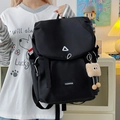 Detail of waterproof nylon backpack featuring flap closure and plush charm accessory - Large Black With Brown Cloud Tag and Charm