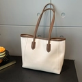 Minimalist beige tote bag with brown leather handles and spacious interior for commuting - White