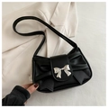 Detail of black pleated shoulder bag with silver metallic bow buckle on textured fabric - Black