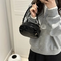 Glänzende schwarze Umhängetasche aus Lackleder mit verstellbarem Gurt am Model - Schwarz