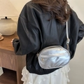 Silberne ovale Umhängetasche aus PU-Leder mit verstellbarem Gurt an weiblichem Modell - Silber