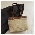 Vue détaillée du sac cabas en paille fait main avec garniture en cuir brun et œillets - Marron