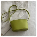 Detail der lindgrünen Schultertasche aus PU-Leder mit verstellbarem Gurt auf weißem Stoff - Grün