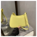 Detail of yellow baguette bag with grain texture and Fashion print in life setting - Yellow