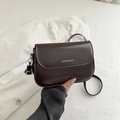 Sacoche marron foncé en cuir brillant avec logo argenté en situation de style - Marron
