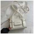 Detail of white PU leather square bag with gold FASHION text and top handles - White